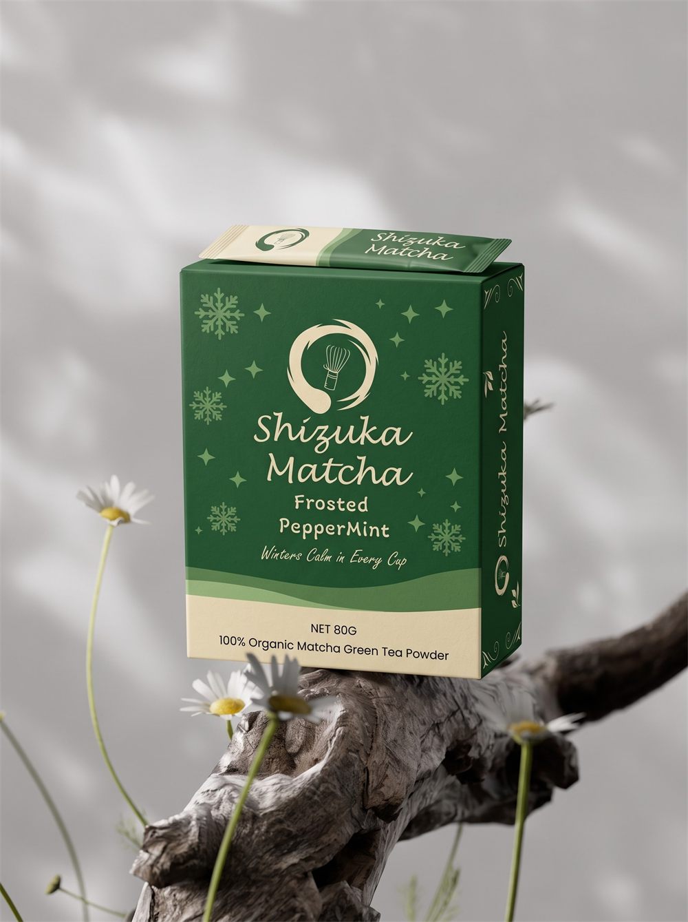 Shizuka Matcha Frosted Peppermint box balanced on a branch with daisies in the foreground
